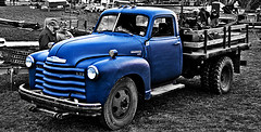 Blue delivery truck in muddy lot